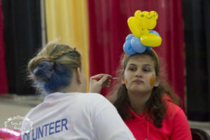 a young girl having her face painted